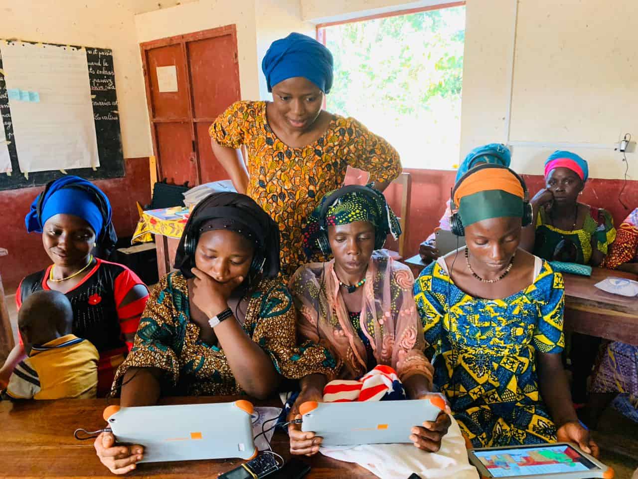 Women taking a mother tongue course on Action Education tablets